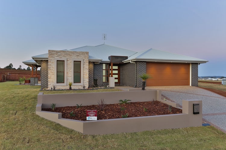 Outdoor view of new home with grey brick and stone feature
