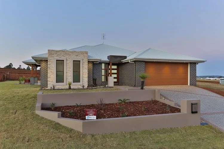 Outdoor view of new home with grey brick and stone feature