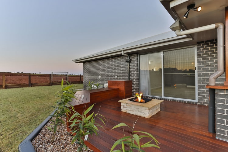 Outdoor area with firepit and timber flooring and bench seats