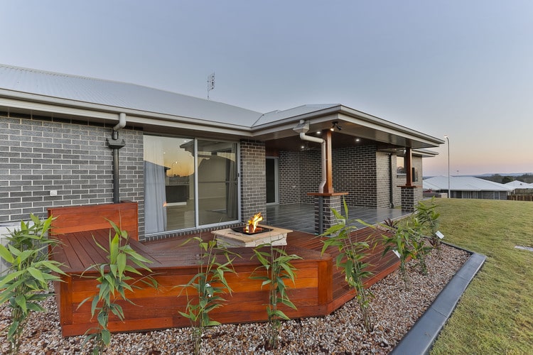 Outdoor patio area with bamboo plants, timber area, firepit and grey tiles