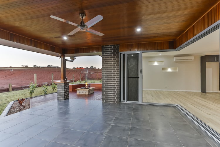 Grey tiled patio area opening onto sliding doors and indoor open plan