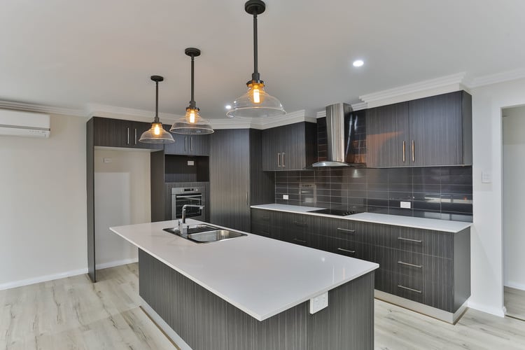 Grey laminate kitchen with white benches and grey floors