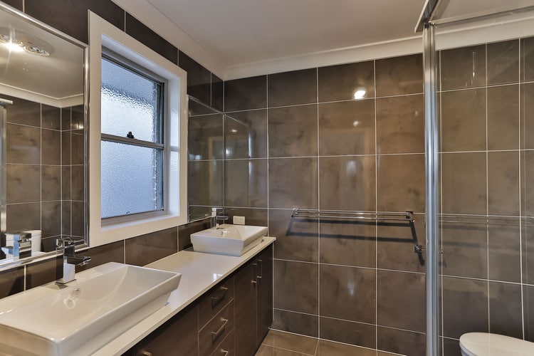 Grey tiled bathroom with double vanity