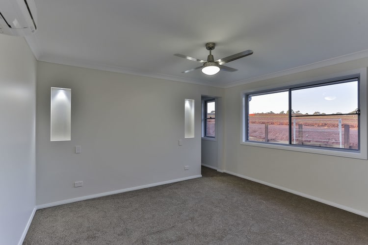 White room with grey carpets and ceiling fan