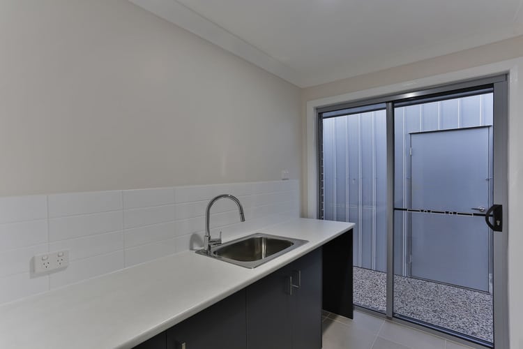 White walls and grey cupboards in laundry area