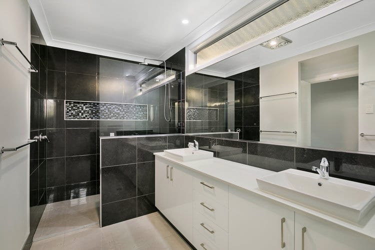 White and black bathroom with shower area and double vanity