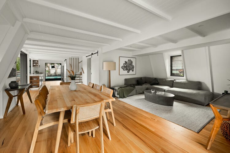 White indoor area with timber floors and grey furniture