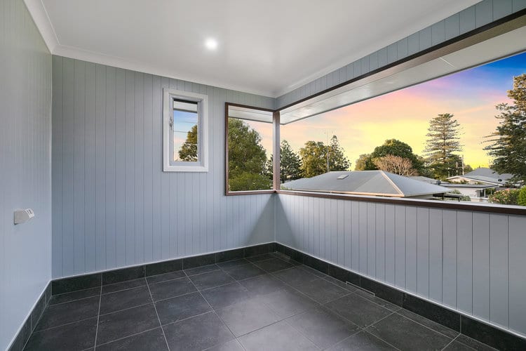 Grey verandah on second storey, with black tile floors