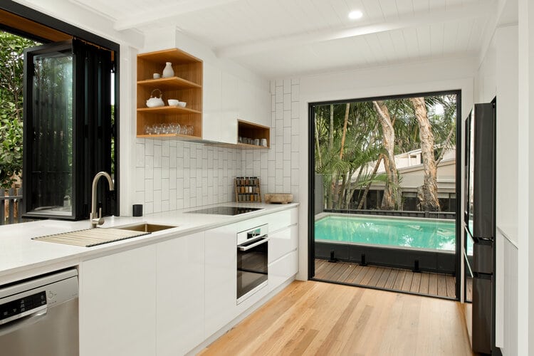 Indoor kitchen area with pool and open shutters