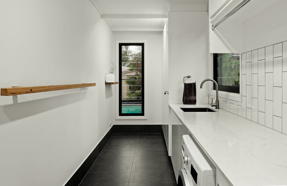 White laundry with grey tiles and black window frames
