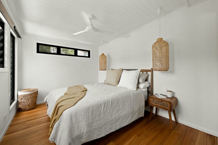 Master bedroom with timber floors and white walls and ceiling fan