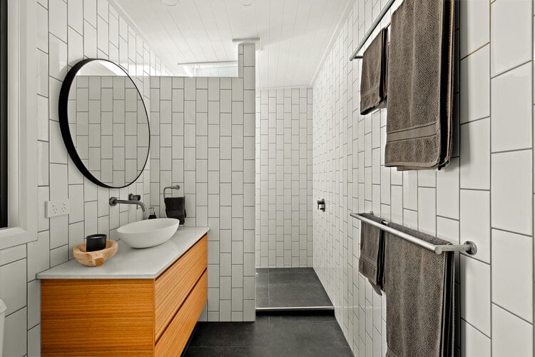 White tiled bathroom with timber counter