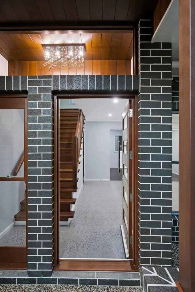 Black brick entryway and timber stairs