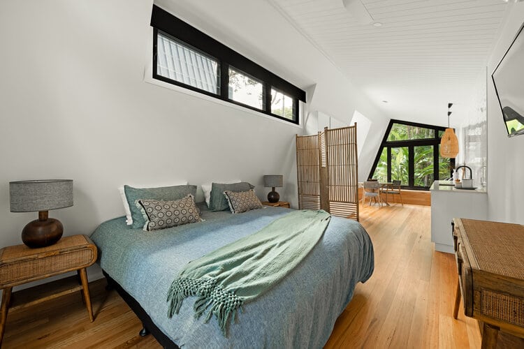 Master bedroom with black windows and timber floors