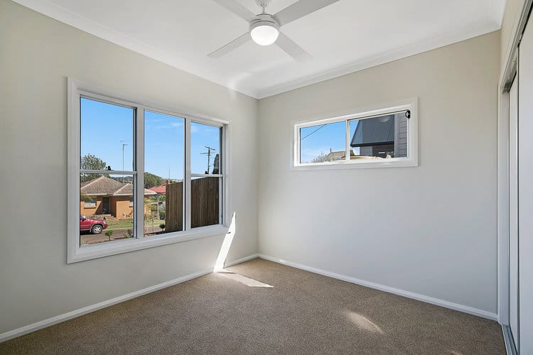 Empty room with sliding wardrobe and white windows