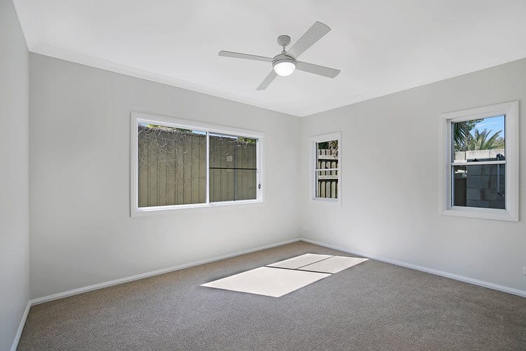 Large room with white walls and grey carpets