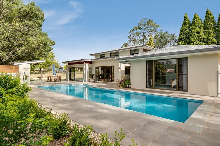 White double storey home and swimming pool