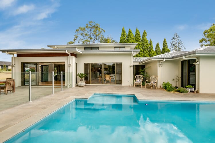White double storey home and swimming pool