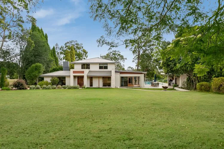 White double storey home and swimming pool