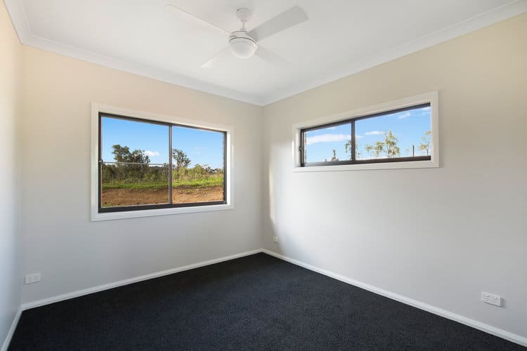 Empty bedroom with white walls and grey carpets