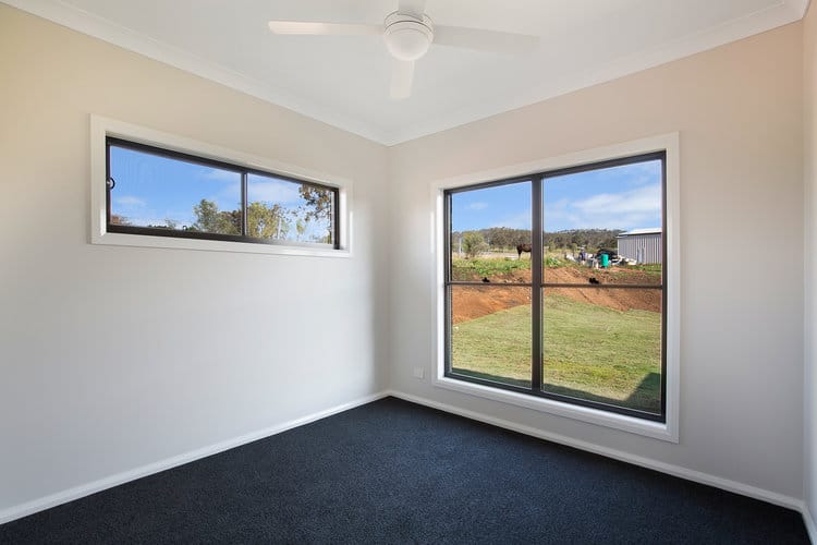 Empty white room with grey carpets and two windows