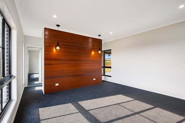 Room with grey carpet, white walls and timber feature wall