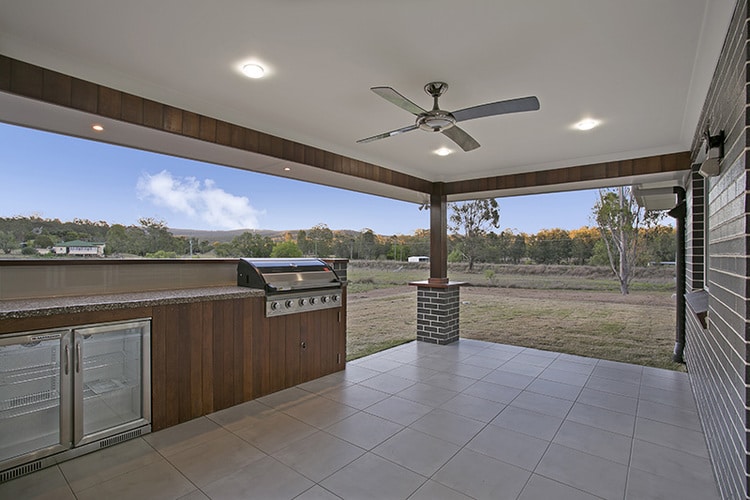 Outdoor patio area featuring ceiling fan and backyard