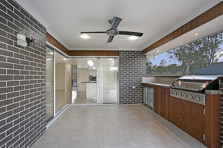Outdoor patio area with grey brick and grey tile and barbecue
