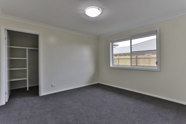 White empty room with grey carpets and walk in robe
