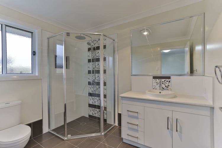 Corner shower with brown feature tiles and white vanity