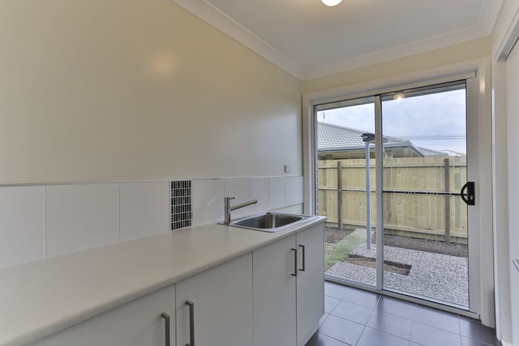 White laundry with sliding door and grey tile floors