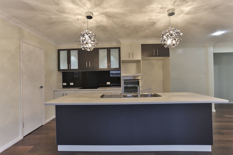 Dark blue, white and grey kitchen with two large lights and white walls