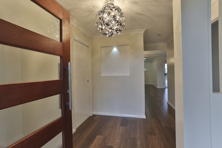 Front hall featuring large costume light and white walls