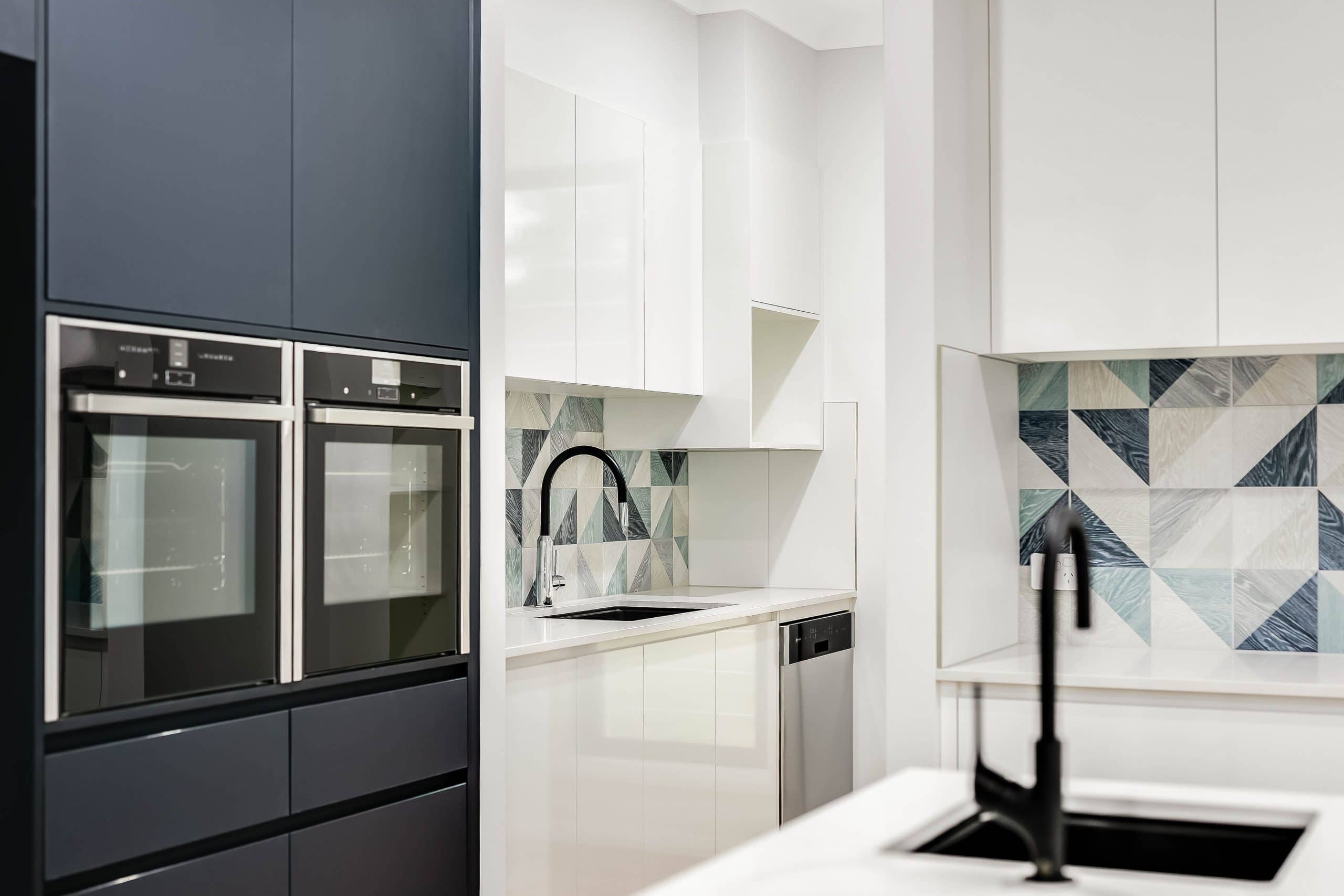 A double oven and two kitchen sinks with blue trimmings