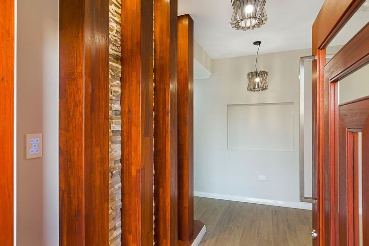 Entry way of house featuring timber, rock and white walls